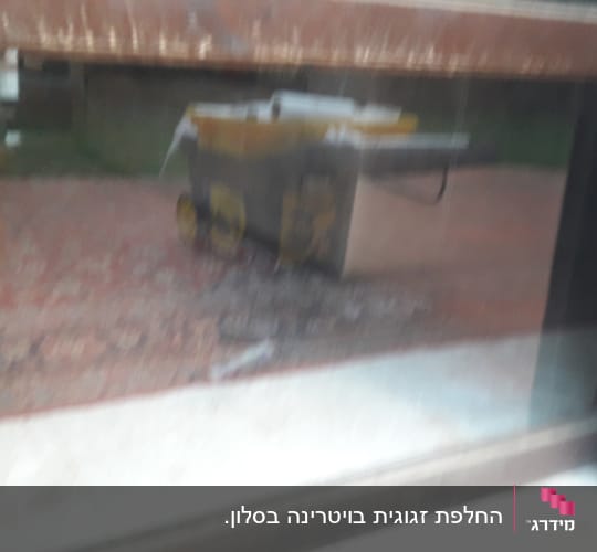 השתקפות של עגלה צהובה על זכוכית חלון
